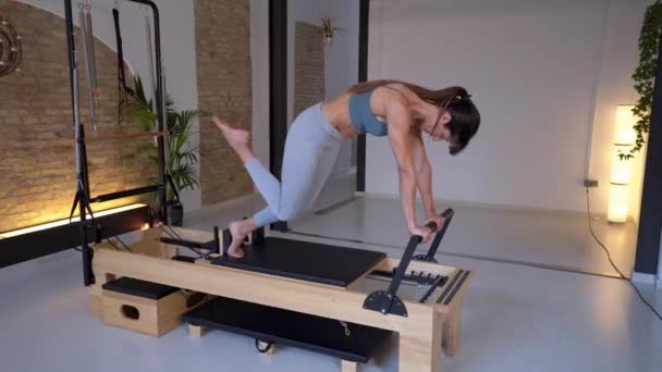 Flexible Graceful Female Doing Exercises Pilates Reformer While Stretching Legs — Stock Video