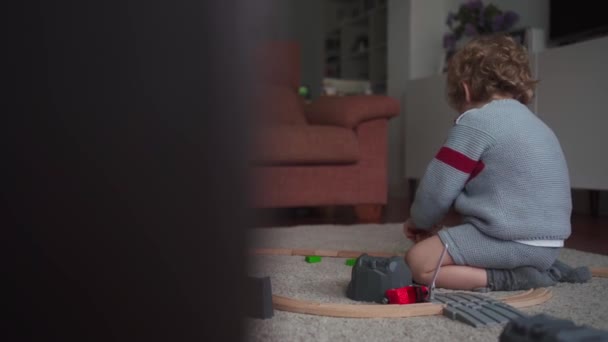 Kıvırcık Saçlı Küçük Çocuk Evde Oyuncak Yol Arabalarla Oynuyor — Stok video