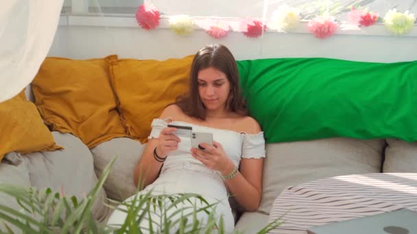 Jovem Conteúdo Feminino Sentado Sofá Fazendo Pagamento Com Cartão Plástico — Vídeo de Stock