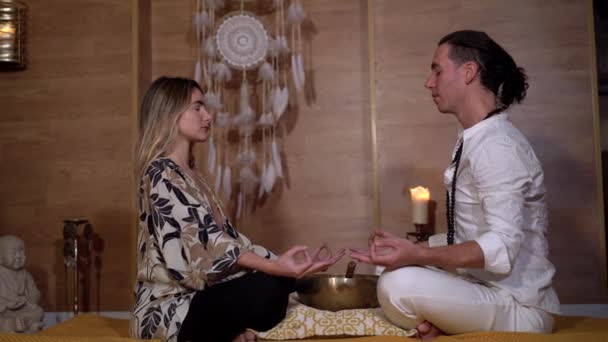精神的な練習中に足と目を閉じた座っている女性のパートナーと禅の先生の側面図 — ストック動画