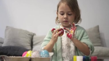 Mutlu Paskalyalar. Güzel küçük kız Paskalya yumurtasını boya ve dekore et.