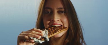 Genç ve güzel bir kadın, fındıklı çikolata yerken çok hoş bir deneyim yaşıyor.