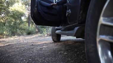 Genç adam ormanda off-road arabasıyla seyahat ediyor. 