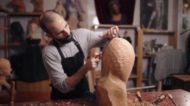  Erkek sanatçı Wood Sculptor atölyesinde çalışıyor.