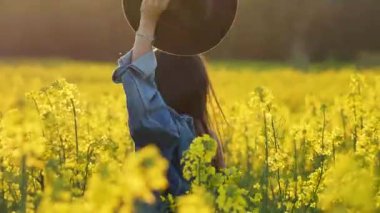 Beyaz silindir şapkalı, ceketli, elinde şapkasıyla neşeli genç bir esmer güneşli bir günde çiçek açan ırz tohumları tarlasında gülüp eğleniyor.