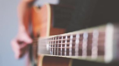 Elinde akustik gitarla gitar çalan bir adamın ekin görüntüleri.. 