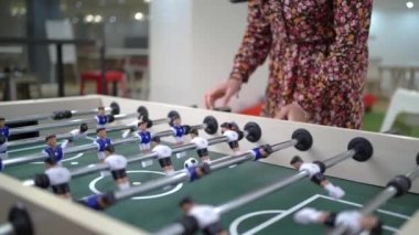 Tanımlanamayan erkek ve kadın iş arkadaşları modern ışık ofisinde mola verirken langırt oynuyorlar.