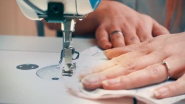 Atölyede dikiş diken genç bir kadın.