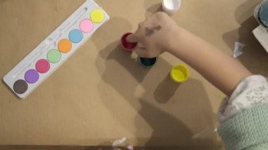 Mutlu Paskalyalar. Güzel küçük kız Paskalya yumurtasını boya ve dekore et.