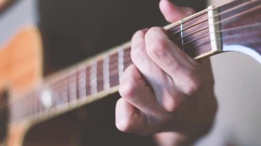 Elinde akustik gitarla gitar çalan bir adamın ekin görüntüleri.. 