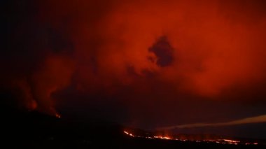 Geceleri La Palma Adası 'ndaki kayalık dağ yamacında yanan lavların dramatik manzarası.