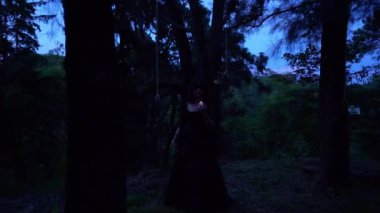 Gece ormanında mumlu güzel cadı fantezi kızı.