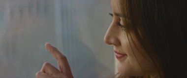 Romantik kadın evdeki yoğun pencereye kalp çiziyor.