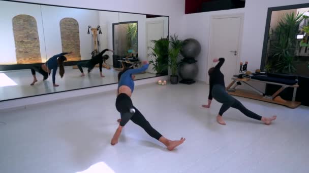 Aktif Giyimli Ince Bayanların Yukarısından Geniş Stüdyoda Ayna Eşliğinde Yoga — Stok video