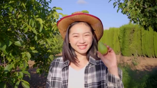田舎の夏の庭の悪い実を見ながら 梨全体と熟した梨に笑みを浮かべて悲しい気持ちを表現する民族女性農家 — ストック動画
