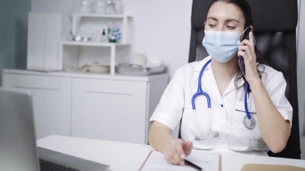 Doctora Joven Usando Abrigo Blanco Escribiendo Notas Lugar Trabajo — Vídeos de Stock