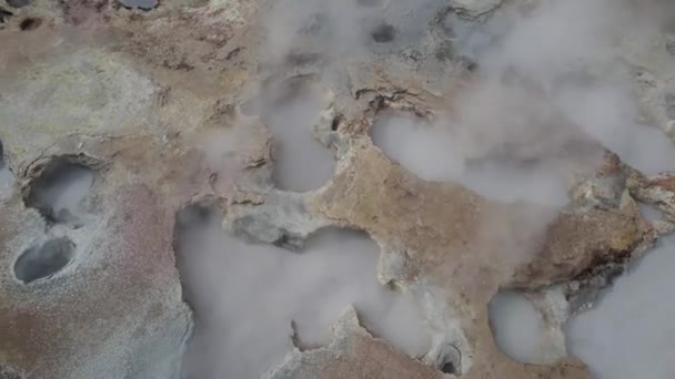 上記のパンから アイスランドの田舎の地面の火山の破裂で沸騰し蒸し沸騰する地熱泉の熱湯のドローンビュー — ストック動画