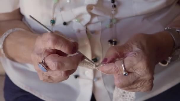 古い女性は手の近くに編む — ストック動画