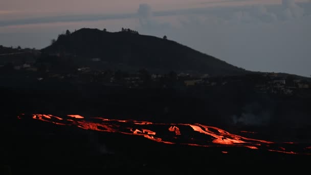 ラパルマ島の曇りの夜空に対する典型的な住宅の家と町を取り巻く火山の噴火と山の尾根の息をのむような景色 — ストック動画