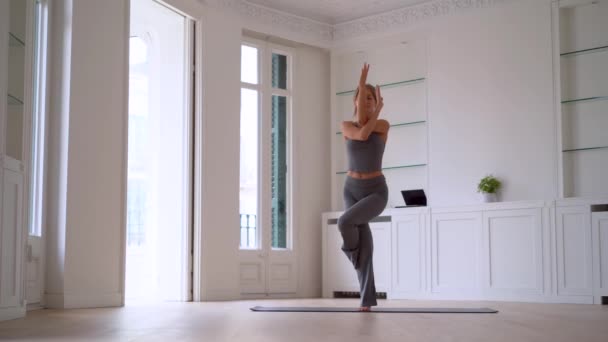 在家中站立和在垫子上保持平衡时 将女性的伸展腿与各种瑜伽姿势合为一体 — 图库视频影像