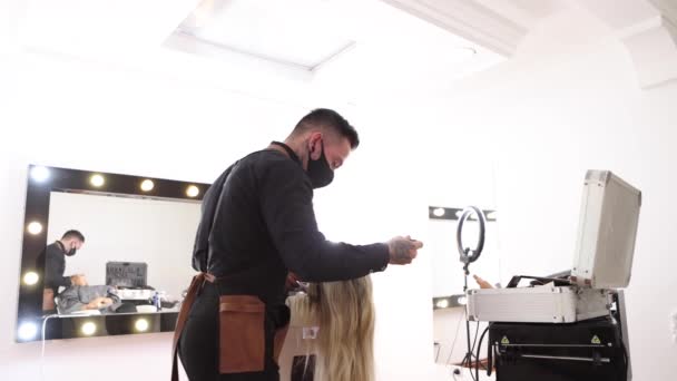 Mężczyzna Masce Rozmazuje Fundament Twarzy Blondynki Podczas Pracy Profesjonalnym Studio — Wideo stockowe