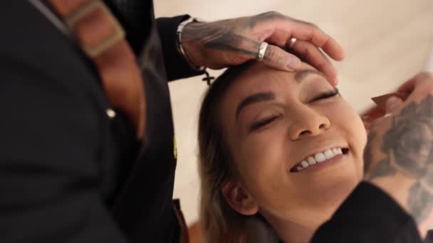 上から幸せな女性の笑顔とお化粧セッション中に舌を見せますタトゥーのある訪問でサロン — ストック動画