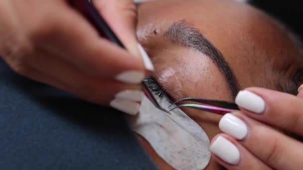 Kosmetolog Stosujący Sztuczne Rzęsy Celu Rozszerzenia Oko Klienta Noszącego Ochronną — Wideo stockowe