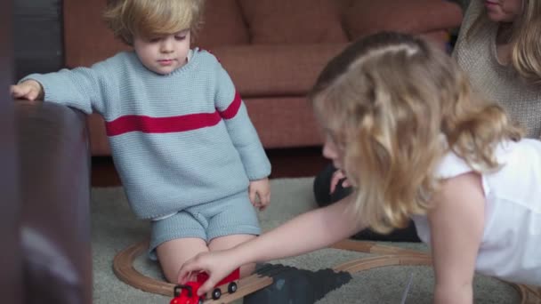 Junge Frau Mit Kleinem Sohn Und Tochter Spielt Mit Spielzeugstraße — Stockvideo
