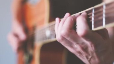 Elinde akustik gitarla gitar çalan bir adamın ekin görüntüleri.. 