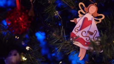 Geceleri parlayan yapay Noel ağacının dallarına asılı melek ve yıldız şekilli süslemeler.