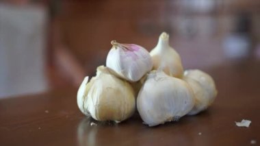 İnsan eli masadan sarımsak alıyor.