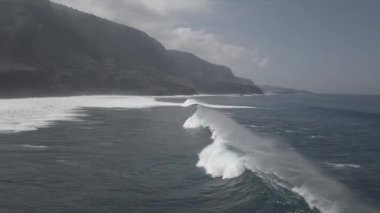 Güçlü köpüklü dalgaların İHA görüntüsü Tenerife adasında dalgalı deniz kıyısında süzülüyor