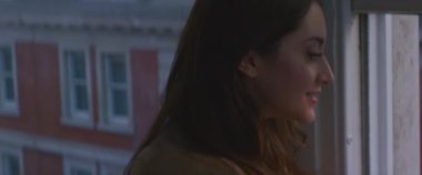 Londra 'nın şehir caddesini akıllı telefonlu bir pencereden videoya çeken kadın.
