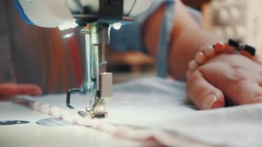 Atölyede dikiş diken genç bir kadın.