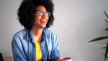 Gözlüklü, siyah kıvırcık saçlı ve gündüzleri deniz fenerinde akıllı telefonlara bakarken bir fincan çayla gülen neşeli Afro-Amerikan kadın. 