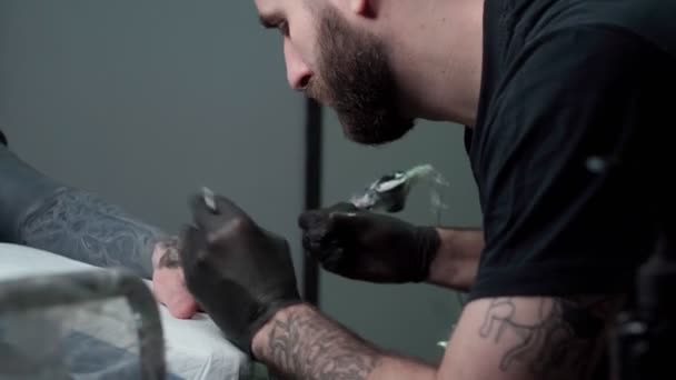 Koncentrált Férfi Tetováló Kesztyű Hogy Tetoválás Kezét Ügyfél Használata Közben — Stock videók