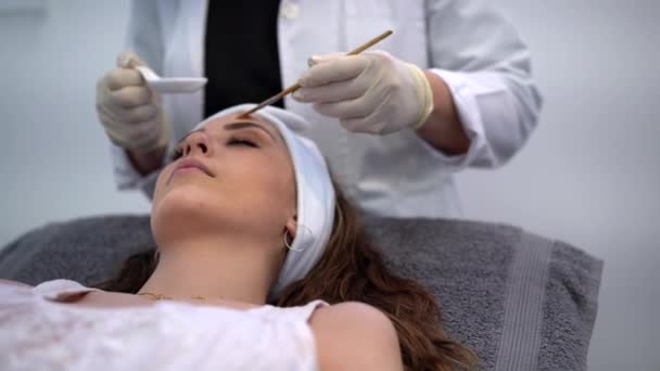 Cosmetólogo Cultivos Anónimo Aplicando Peeling Ácido Cara Del Cliente Femenino — Vídeos de Stock