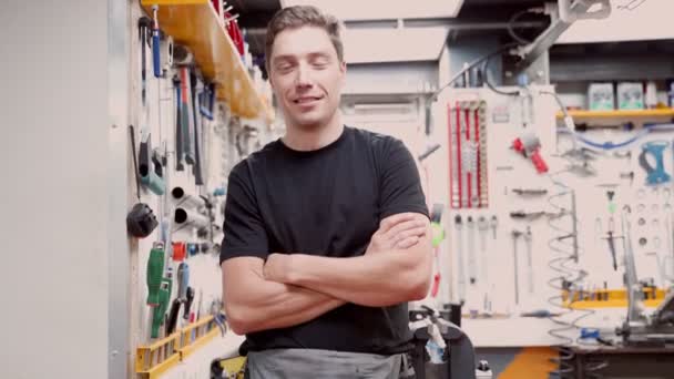 Feliz Mecánico Masculino Sonriendo Mirando Cámara Contra Pared Con Herramientas — Vídeos de Stock