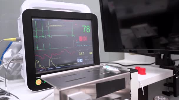 診療所のテーブルに表示される心拍数グラフおよび数を示す専門の医療装置 — ストック動画