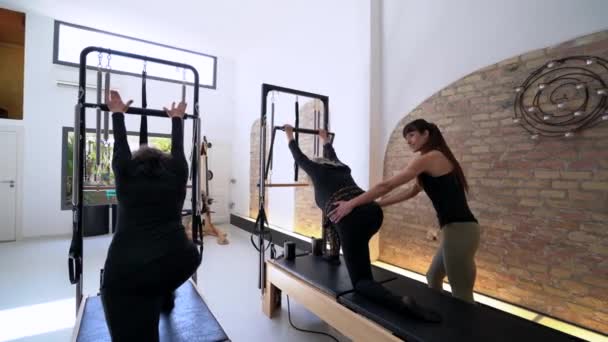 Back View Group Flexible Females Stretching Legs Pilates Reformer While — Stock Video