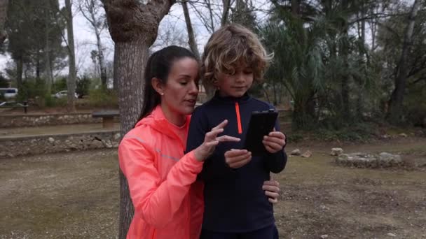Šťastná Maminka Sportovním Oblečení Vysvětlující Okouzlující Chlapec Při Interakci Mobilním — Stock video