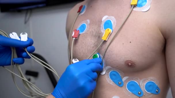 用于心脏心电图诊断的连接电极与男性患者胸部的作物匿名介质 — 图库视频影像