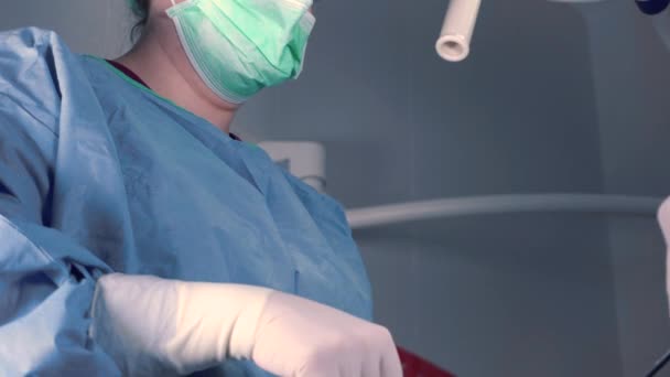 Ameliyathanede Parlak Işık Altında Dururken Profesyonel Aletler Kullanan Tıp Üniformalı — Stok video