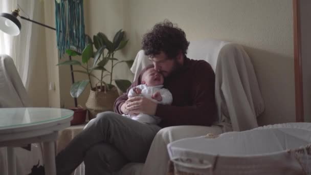 Дорослий Бородатий Батько Тримає Маленьку Дитину Сидячи Кріслі Кімнаті — стокове відео