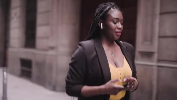 Запись Молодой Афроамериканской Женщины Черном Костюме Идущей Улице Смартфоном — стоковое видео