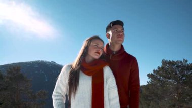 Genç çift kışın karlı ormanda aşık.