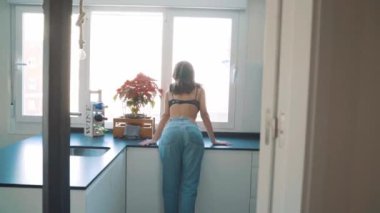 Genç esmer, seksi kadın odada poz veriyor.