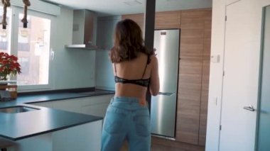 Genç esmer, seksi kadın odada poz veriyor.