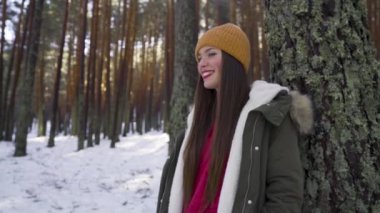 Genç ve mutlu bir kadın kış ormanında