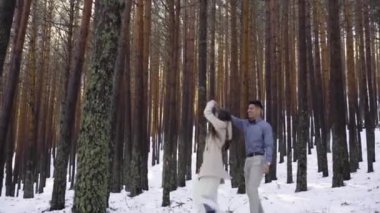 Genç çift kışın karlı ormanda aşık.